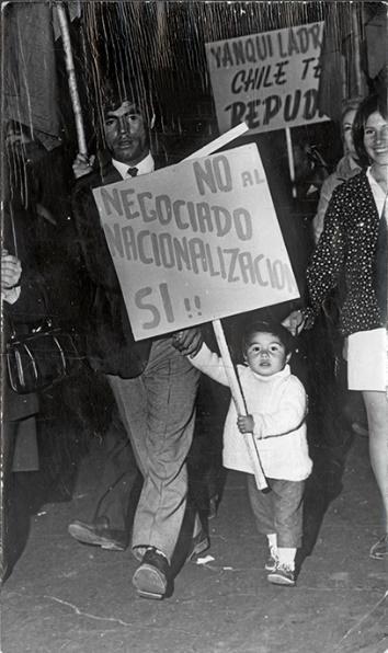 Foto en blanco y negro de un grupo de personas con paraguas en mano Descripción generada automáticamente